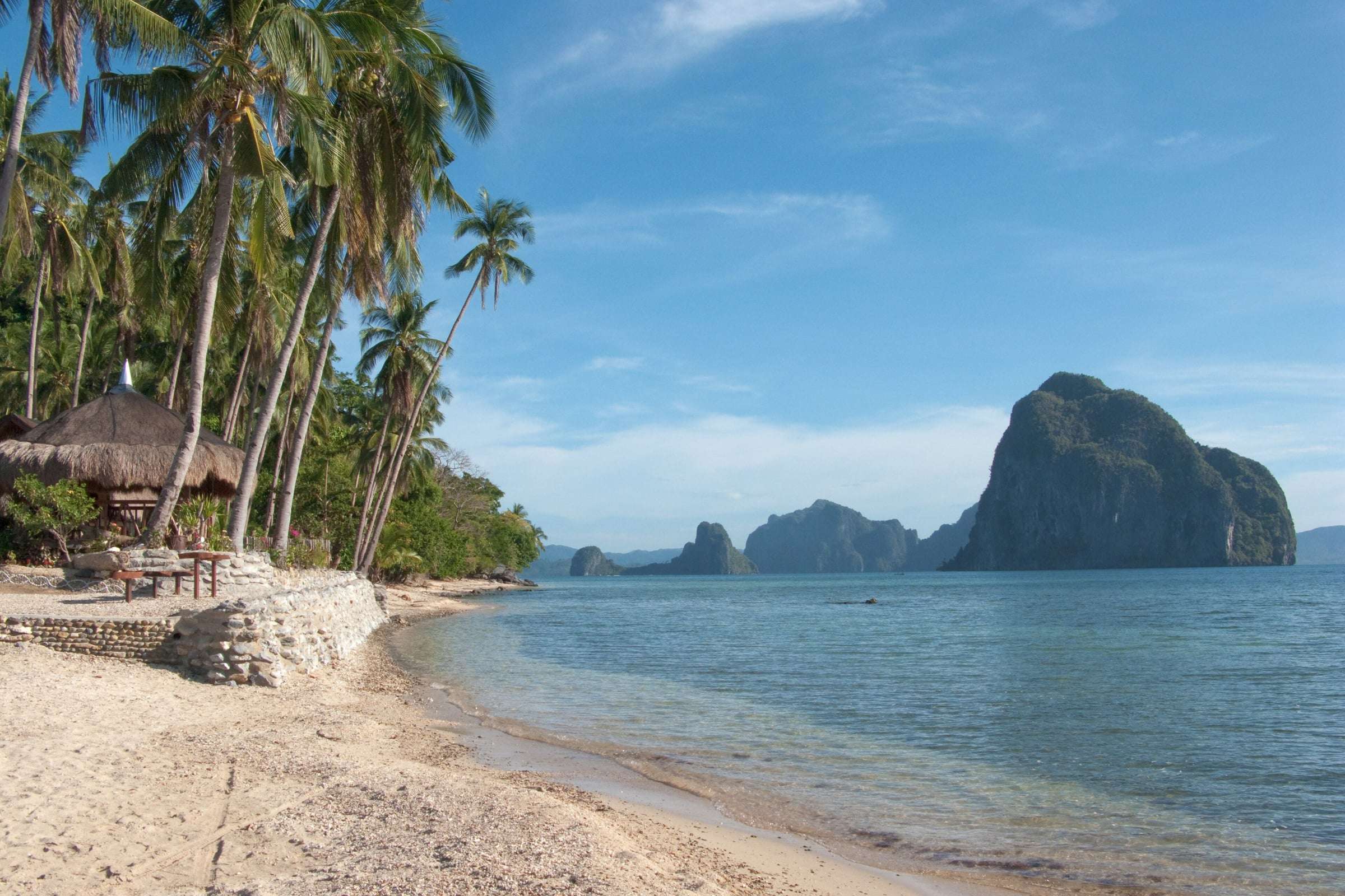 Wide sweep of Corong-Corong beach near El Nido — calm water, fine sand and palms