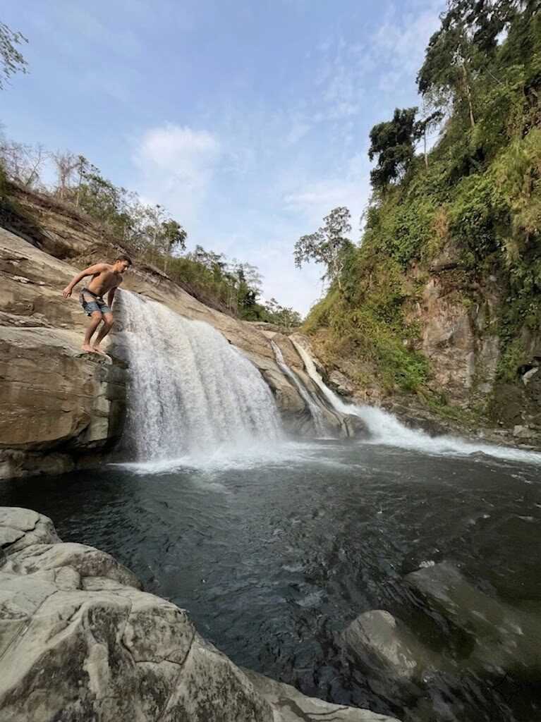 Tangadan Falls La Union waterfall flowing into natural deep pool with cliff jumping platform in San Gabriel