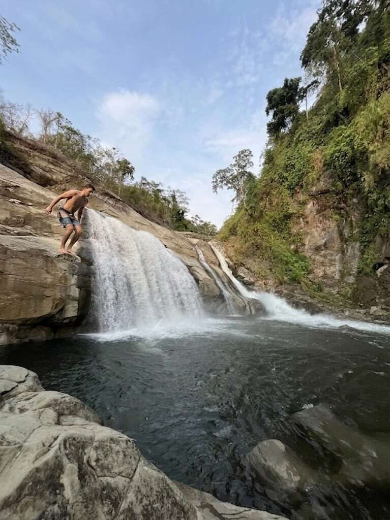 Tangadan Falls La Union waterfall flowing into natural deep pool with cliff jumping platform in San Gabriel