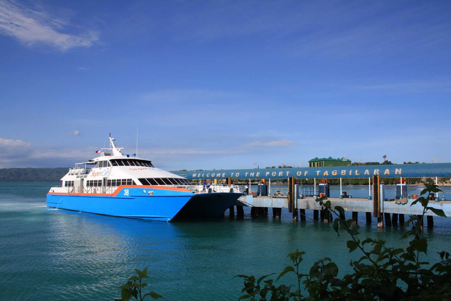 A SuperCat fast ferry docking under the Welcome to the Port of Tagbilaran sign in Bohol