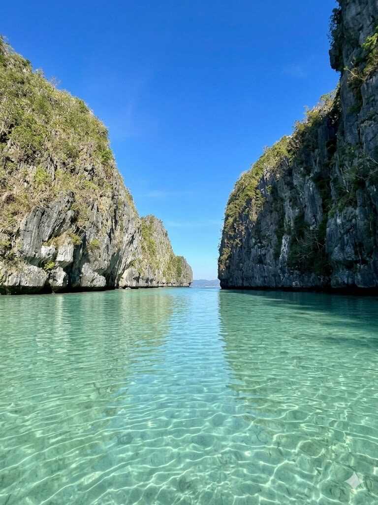El Nido Big Lagoon clear turquoise water between towering limestone karst cliffs in Palawan Philippines
