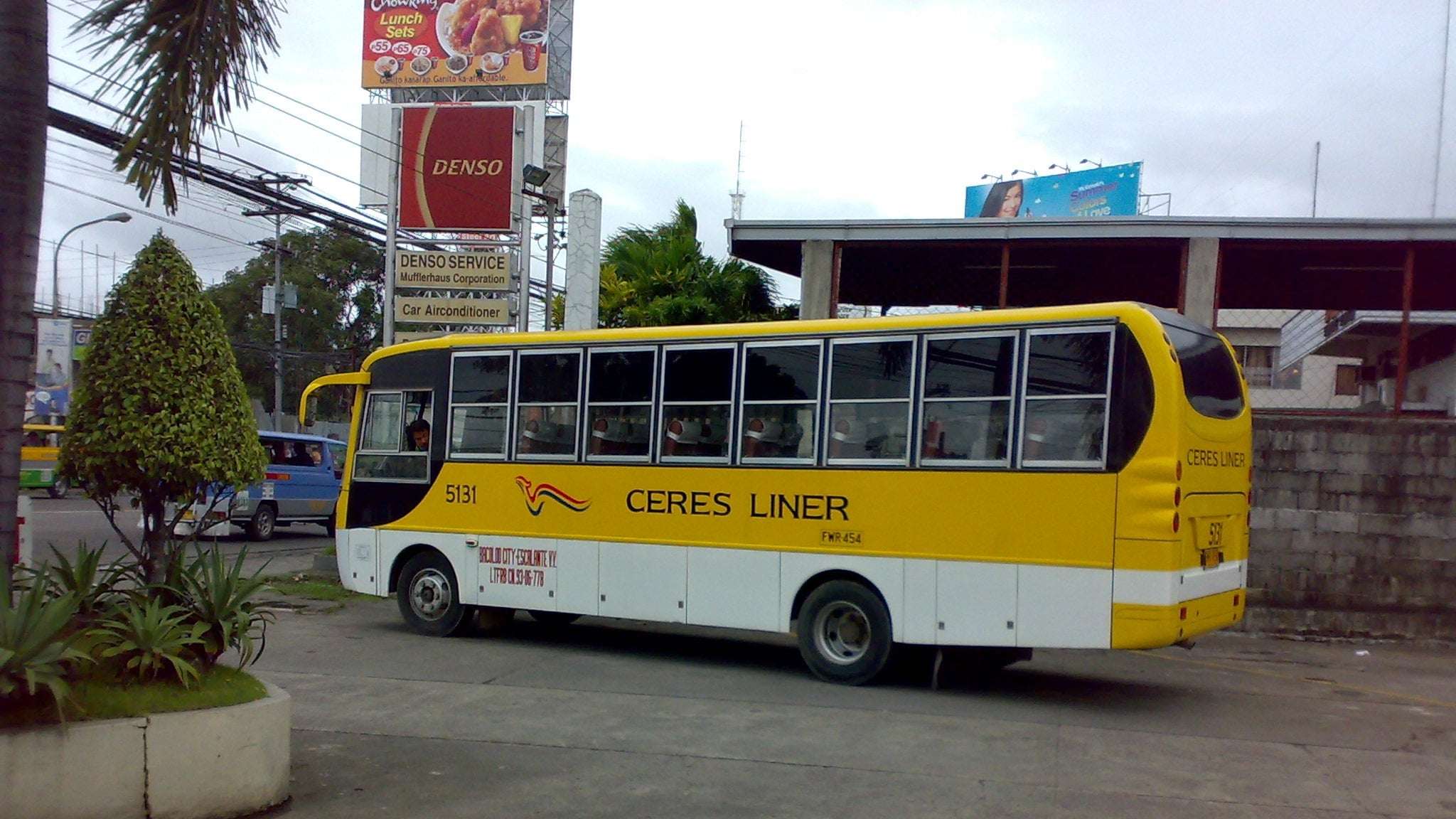 A yellow Ceres Liner bus parked at a terminal, the kind that runs from Cebu South Bus Terminal to Moalboal