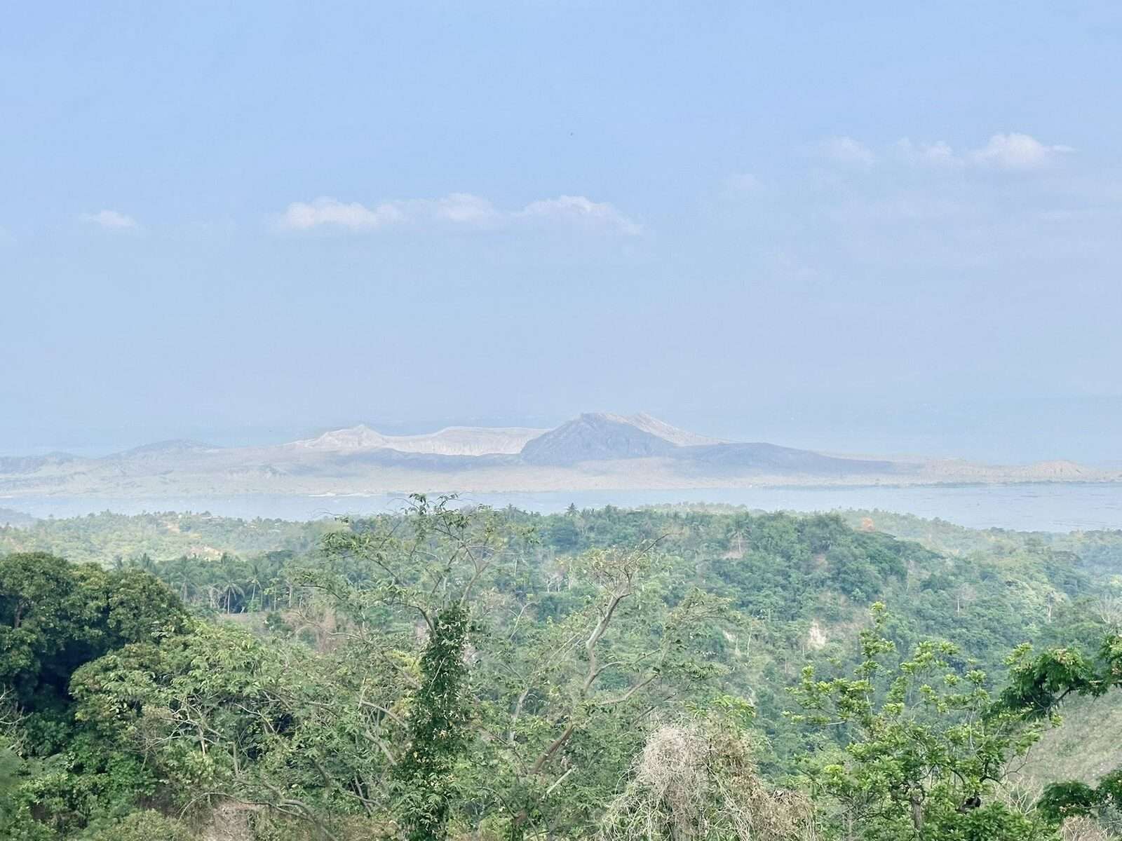 Taal Volcano view from Tagaytay ridge showing the famous volcano-within-a-lake crater landscape with lush green jungle in the foreground