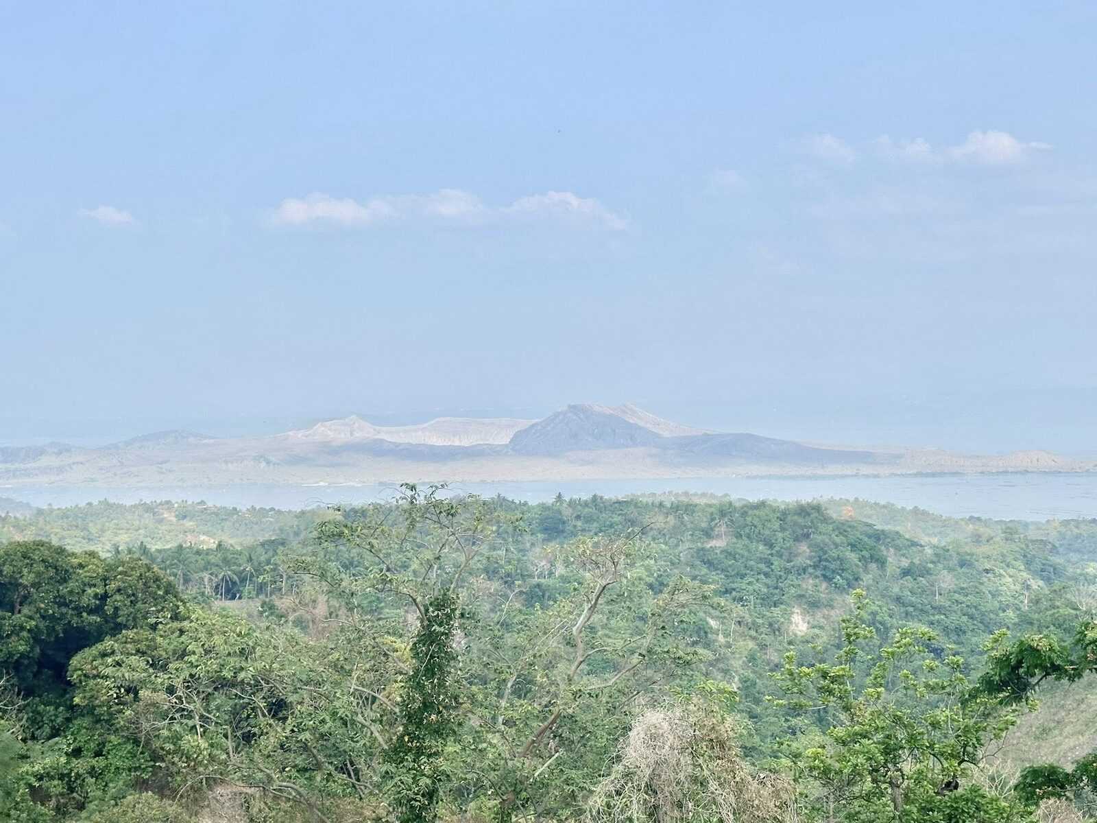 Taal Volcano view from Tagaytay ridge showing the famous volcano-within-a-lake crater landscape with lush green jungle in the foreground